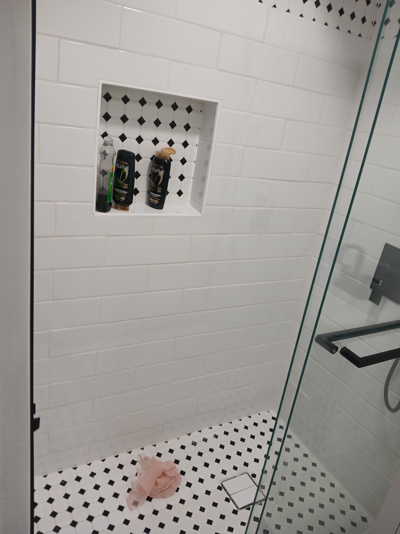 Shower after — black and white subway tile with built-in niche and glass enclosure