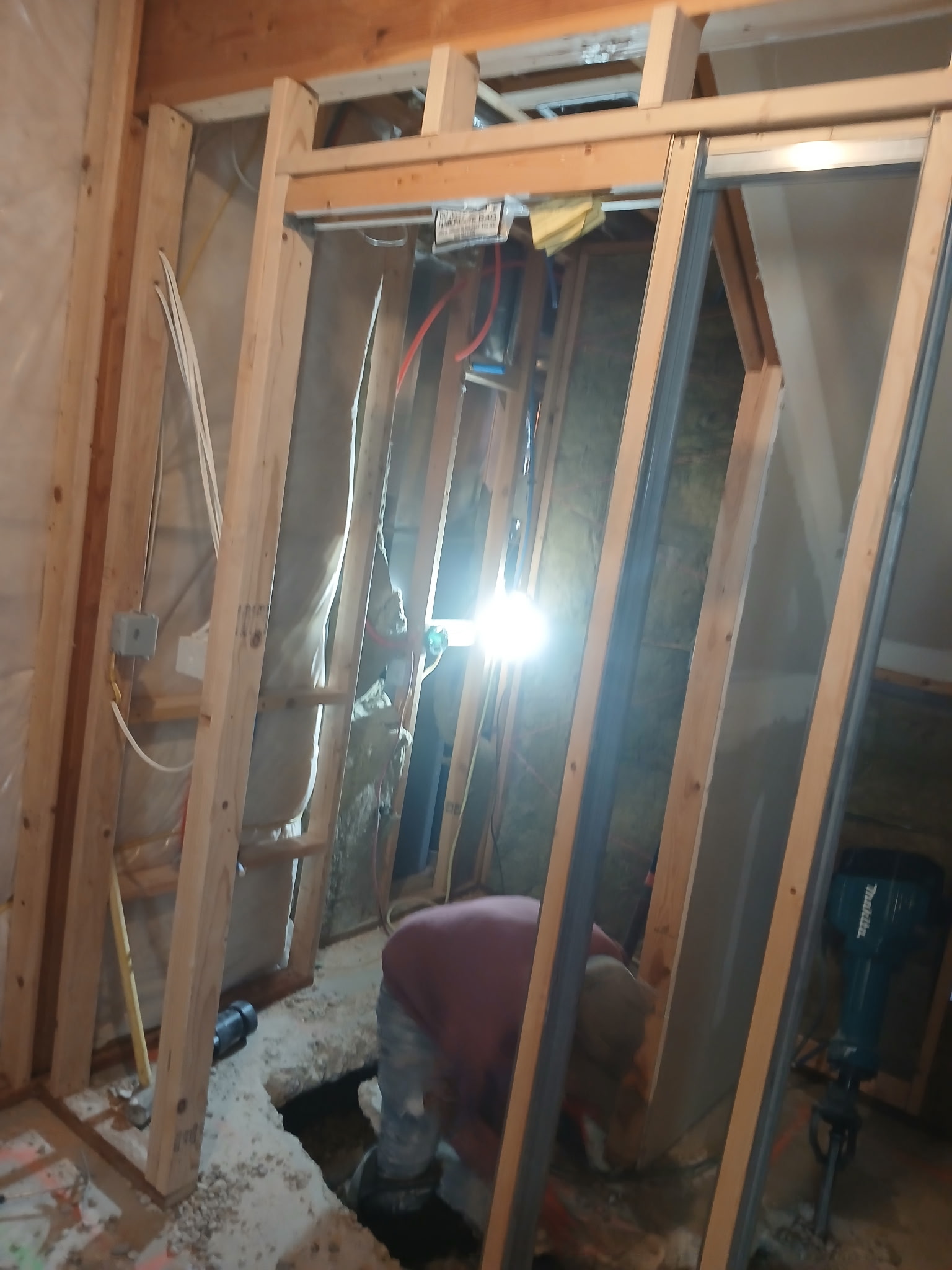 drywall rough opening framing with new lumber, insulation, and plumbing visible