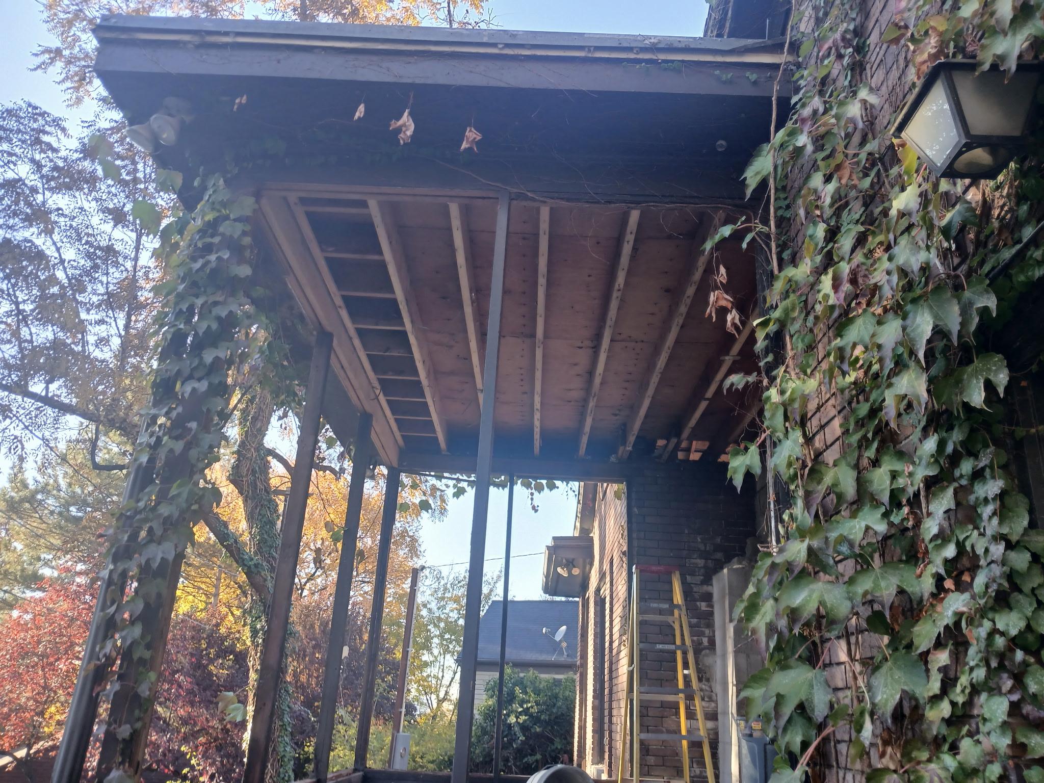 Exterior porch overhang repair with new structural framing and fresh decking boards